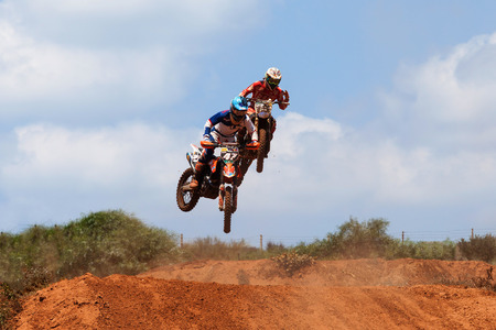 Motocross rider and bike clearing a tabletop jump during the final heat of the raceのeditorial素材