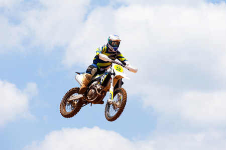 Motocross rider and bike clearing a tabletop jump during the final heat of the race.のeditorial素材