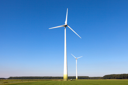 Wind turbine spinning with in a green countryside environmentの写真素材