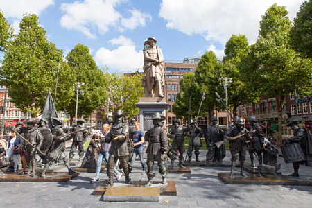 Sculpture of the dutch painter Rembrandt with and installation of Night watch sculptures on a sunny day in Amsterdamのeditorial素材