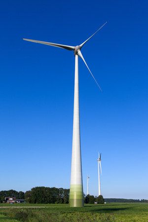 Wind turbine spinning with in a green countryside environmentの写真素材