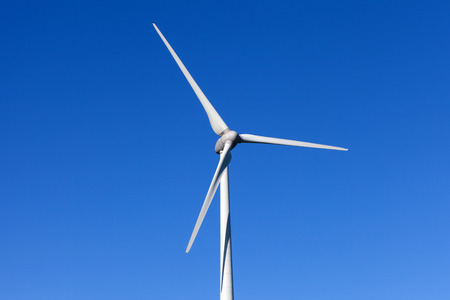 Wind turbine spinning with in a green countryside environmentの写真素材