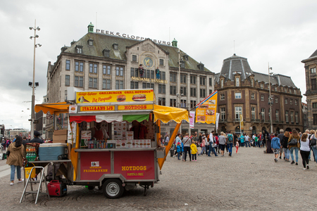 Dam square on a sunny day with locals and tourists at the square and transportation crossing.のeditorial素材