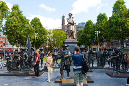 Sculpture of the dutch painter Rembrandt with and installation of Night watch sculptures on a sunny day in Amsterdamのeditorial素材