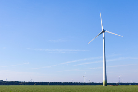 Wind turbine spinning with in a green countryside environmentの写真素材