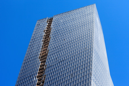Skyscraper during construction with windows and an open gap showing exposed concrete floorsの写真素材