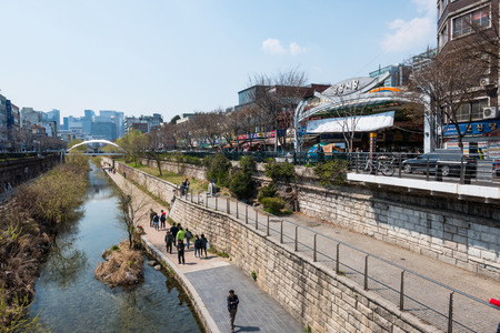 Locals and tourists enjoy a walk at Cheonggye Stream near Dongdaemun Market. A modern public recreation space in downtown Seoul, South Korea.のeditorial素材