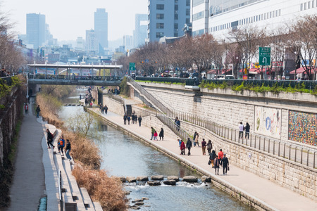 Locals and tourists enjoy a walk at Cheonggye Stream near Dongdaemun Market. A modern public recreation space in downtown Seoul, South Korea.のeditorial素材