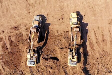Excavators loading soil onto an Articulated hauler Trucks, Top down aerialの写真素材