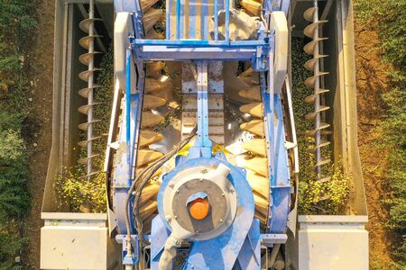 Olive Harvester processing rows of Olive trees, aerial image.の写真素材