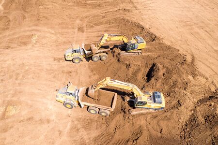 Excavator loading soil onto an Articulated hauler Truckの写真素材