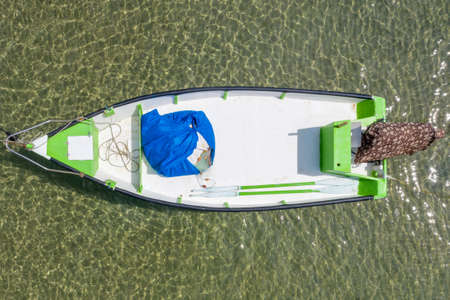 Small Fishing Boat anchored in a shallow lagoon.