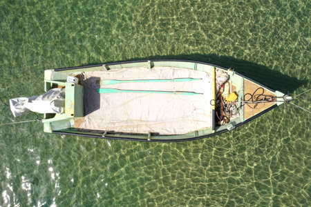 Small Fishing Boat anchored in a shallow lagoon.の写真素材