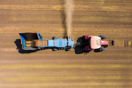 Almond picker harvester processing a field, Aerial view.の写真素材