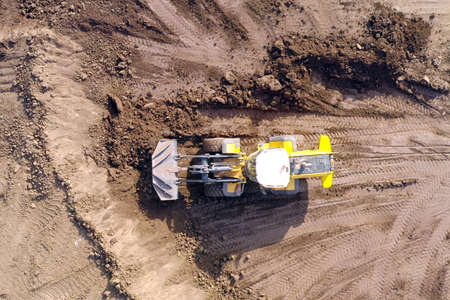 Bulldozer pushing large amount of fresh soil, Aerial shot.の写真素材