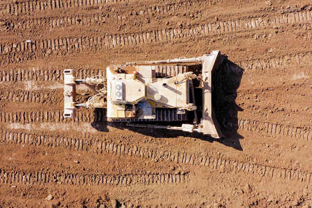 Bulldozer pushing large amount of fresh soil, Aerial shot.の写真素材