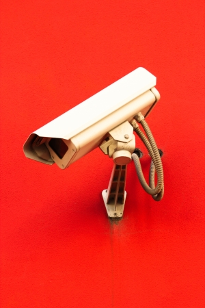 Surveillance video camera on red backgroundの写真素材