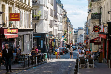 Leisurely people in Paris enjoy the afternoon at the outdoor seating of the street cafe on Rue des Martyrsのeditorial素材
