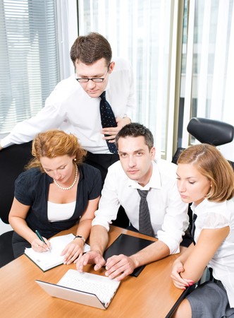 Manager with office workers on meeting in board roomの写真素材