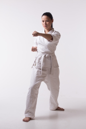 Beautiful woman in kimono show marshal art exercise on whiteの写真素材