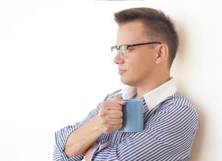 White collar worker with cup think near wallの写真素材