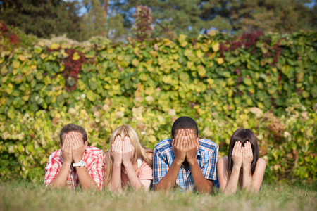 Young student lay in park on grass and close their faces with  hands in parkの写真素材