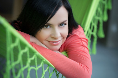 Beautifil woman rest in green hammock indoorの写真素材