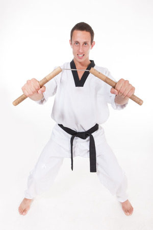 Fighter in  white kimono with nunchaku on white backgroundの写真素材