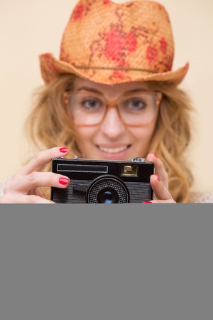 Accentuation on modern camera photo made by beautiful smiling model in white shirt with long red hair.の写真素材