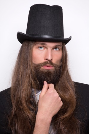 Portrait of magician with long hair and moustache. Serious man posing in photostudio.の写真素材