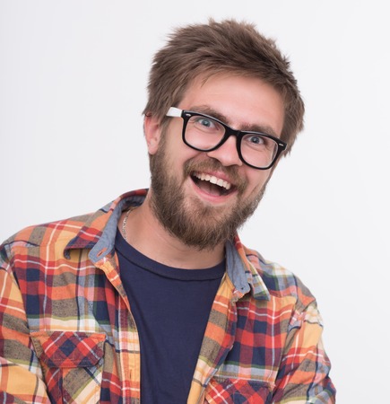 Sexy man with beard smiling big against wall. Man in fashionable glasses posing for photographer with his arms crossed.の写真素材
