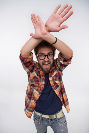 Portrait of young bearded stylish handsome hipster man. Man in glasses raised his hands above his head and screaming much.の写真素材