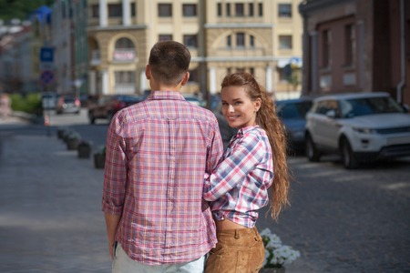 Happy young couple having romantic time outdoors. Woman with long red hair looking into the camera.の写真素材