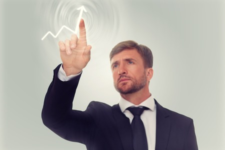 Businessman's hand drawing increasing graph on media screen. Serious man has a desire to see the prosperity of his company.の写真素材