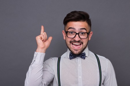 Hipster man happy smiling and pointing out in studio. Handsome man created new idea or concept for his scientific research.の写真素材