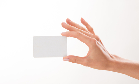 Woman's hand holding a blank credit card over white background. Woman has a desire to demonstrate something on it.の写真素材
