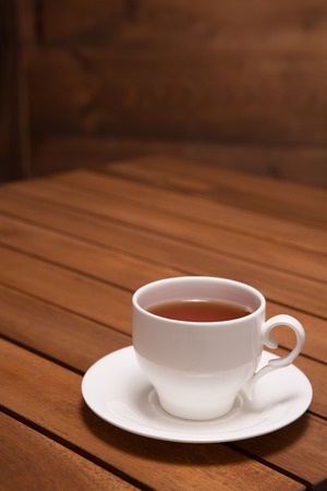 A cup of delicious tea represented on the wooden table in restaurant or cafe. It is nice idea for your post card.の写真素材
