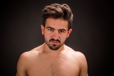 Portrait of young lover in studio. Naked young man looking at the camera after having sex with beautiful woman.の写真素材