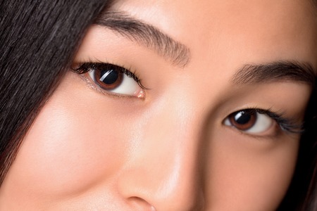 Close-up of piercing glance of asian lady in studio. Beautiful woman looking at camera. Pretty eyes of Asian woman.の写真素材