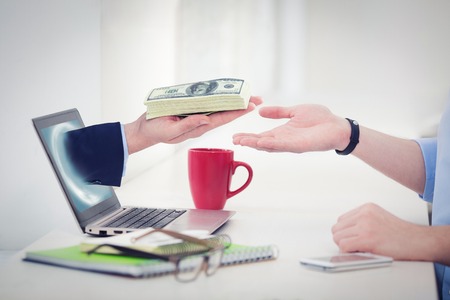 Freelance businessman trying to get money from another hand looking from laptop computer. Male hand...
