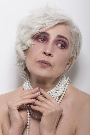 Closeup portrait of beautiful senior woman with short blond hair, beautiful lips and fresh makeup...