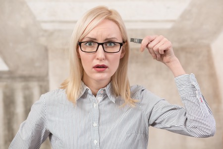 Sad freelance woman holding usb card in office. Beautiful lady in glasses looking at camera...