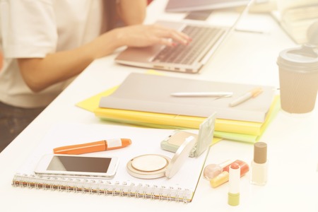 Closeup picture of cosmetics represented among exercise-books, documents and university, colleage or school things for studying. Toned image.の写真素材