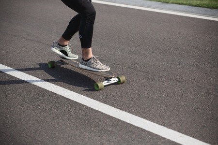 Sportive cool on skateboard or longboard - cool street skateboarder in a urban setting - fashion, sport, lifestyle concepts.の写真素材