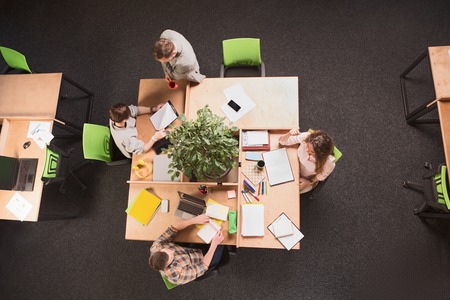 Top view of business people having round tablein office. People working and discussion certain...