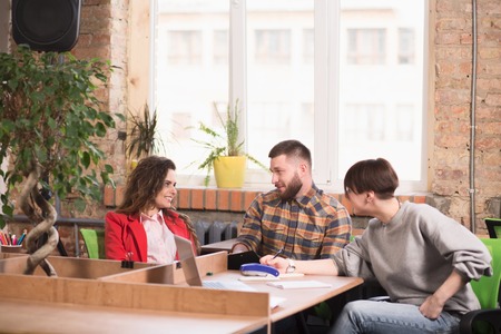Picture of business people sitting at working places and working in office. Happy people discussing business problems and issues.の写真素材