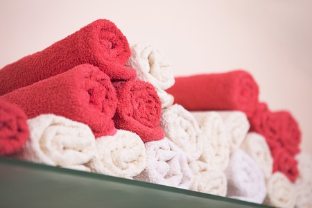 Big bunch of red and white towels in bathroom shelf or hairdressing saloon or beauty saloon.の写真素材