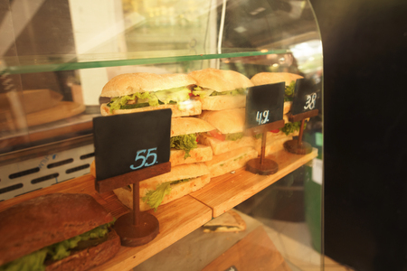 Toned picture of healthy veggie panini sandwiches. Freshly grilled panini with olives, basil leaves, fresh red and green peppers, tomatoes served on ciabatta bread with cream ketchup sauce.の写真素材