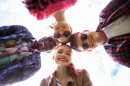 Portrait of best friends posing for camera while making selfies on picnic in park.