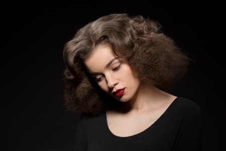 Closeup portrait of beautiful lady with red lips looking downwards.の写真素材